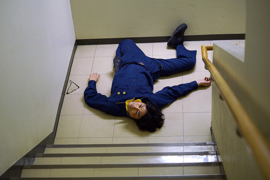 『不能犯』安田顕が関節を180度曲げて倒れる場面写真